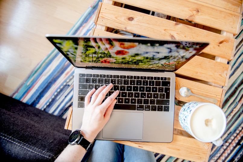 Laptop auf Tisch mit Kaffeetasse daneben