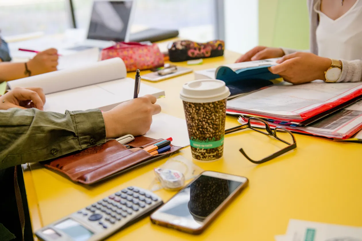 Studierenden lernen am gelben Tisch