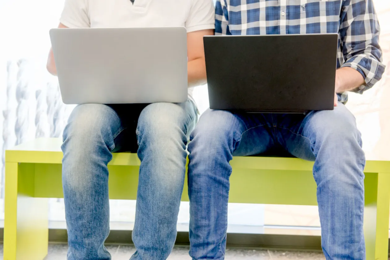 Personen mit Laptop auf den Beinen