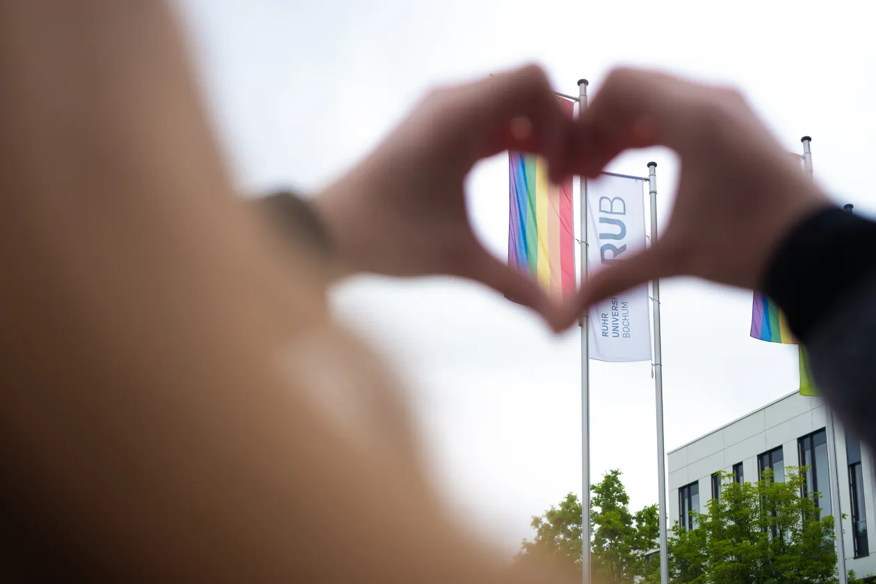 Herzförmige Hände um eine Flagge