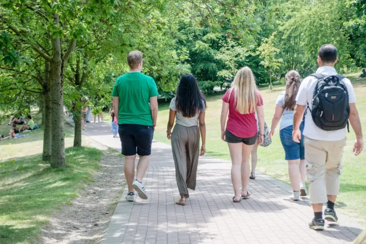 Meschen von hinten auf einem Weg auf dem Campus