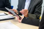 Man points on tablet.