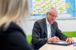 Mann schreibt in ein Dokument.
