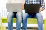 Personen mit Laptop auf den Beinen