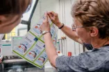 Mitarbeiterin der Buchbinderei erklärt am Ausdruck