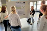 Frauen stehen an einem Poster