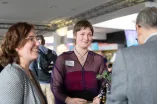 Foto: Mehrere Personen stehen lächelnd zusammen und unterhalten sich.
