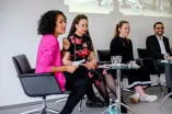 Vier Personen sitzen auf einer Bühne und sprechen miteinander. Es handelt sich um Expert*innen zum Thema Rassismus beim Diversity Sarah Vecera, Nathalie Eleyth, Bonnie Aurich, Karim Fereidooni.
