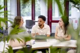 Drei Studierende mit Laptops