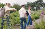 Foto: Drei Studierende gehen durch den Botanischen Garten an der Ruhr-Universität Bochum