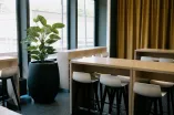 Das Bild zeigt Sitzgelegenheiten und Tische im Café Bari im Open Space GA 02