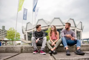 Studierende sitzen am Campus.