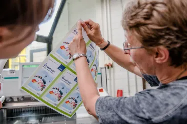 Mitarbeiterin der Buchbinderei erklärt am Ausdruck