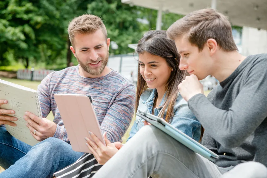 Three students work with tablets