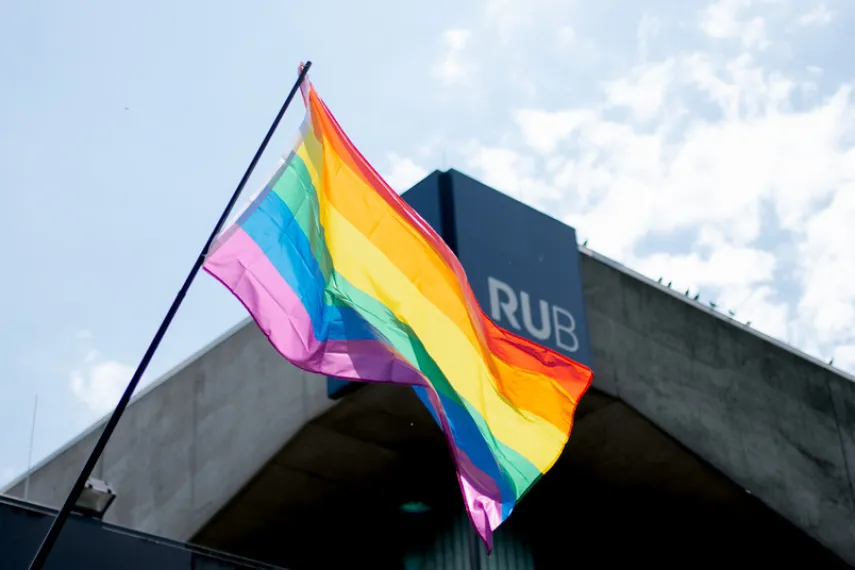 Regenbogenflagge weht vor dem RUB-Schriftzug 