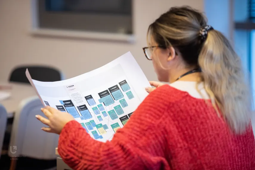 Foto: Junge Frau schaut sich einen Plan an.