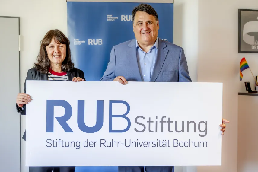 Geschäftsführerin der Stiftung der Ruhr-Universität Bochum Susanne Seiler und Rektor der Ruhr-Universität Bochum Prof. Dr. Martin Paul halten zusammen das Logo der Stiftung der Ruhr-Universität Bochum.