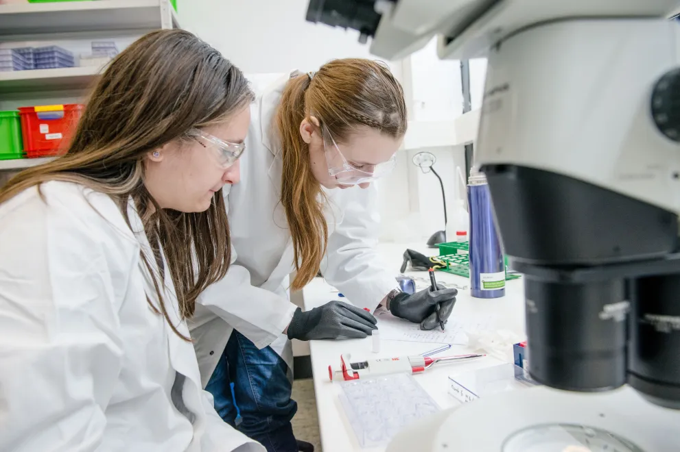 Two female reserchers analyse a sample