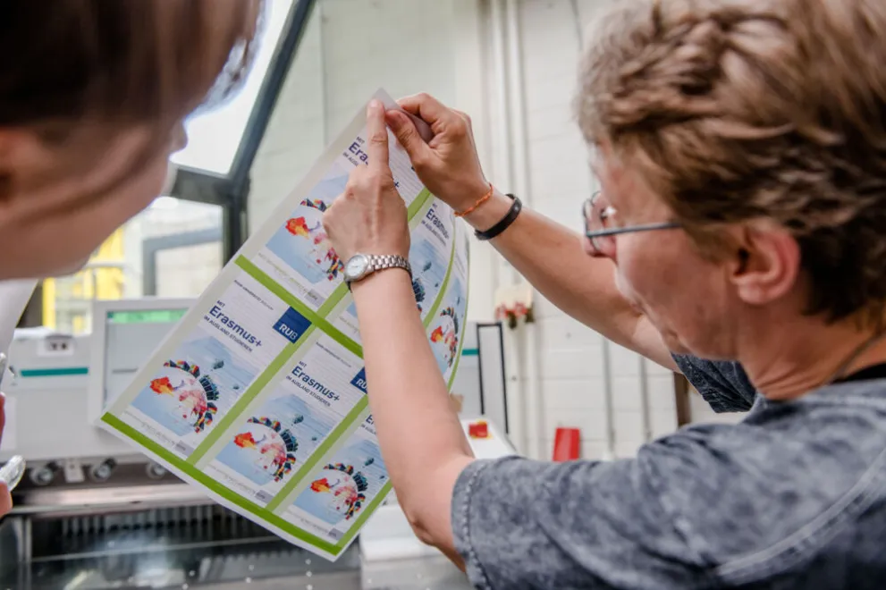 Mitarbeiterin der Buchbinderei erklärt am Ausdruck