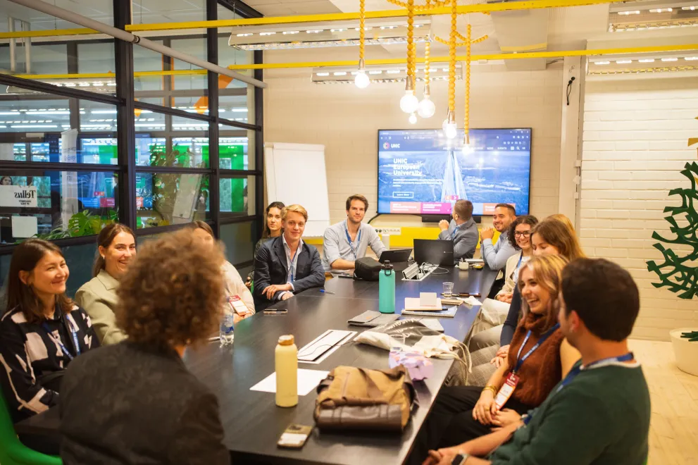 Studierende versammelt um einen Konferenztisch