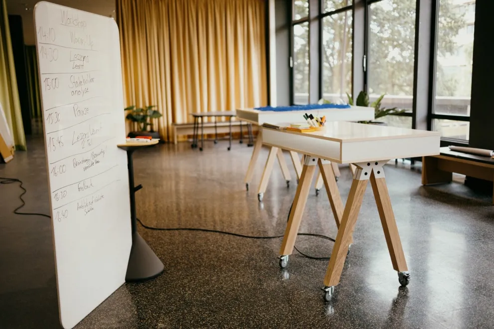 Das Bild zeigt Whiteboards und Tische in der Sandbox im Open Space GA 02